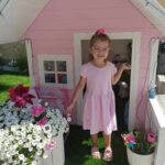 Dziewczyna w różowym domku ogrodowym