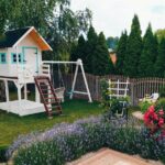 bialy domek na podescie z hustawkami